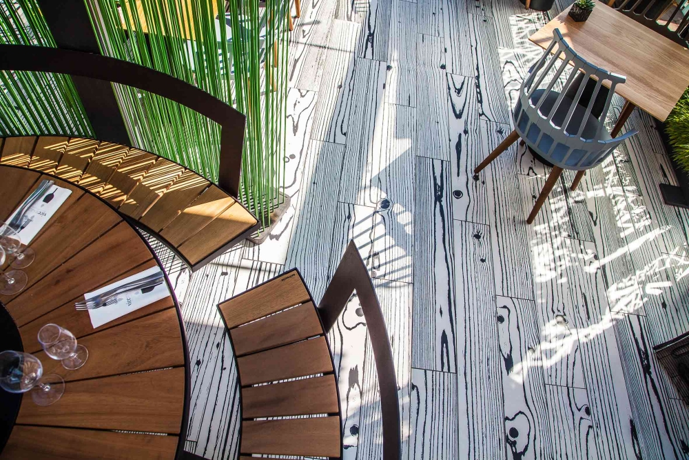 Terrasse moderne avec vue aérienne, mobilier bois et sol graphique