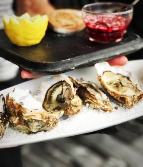 Huîtres grillées servies avec citron et verre de vin rosé