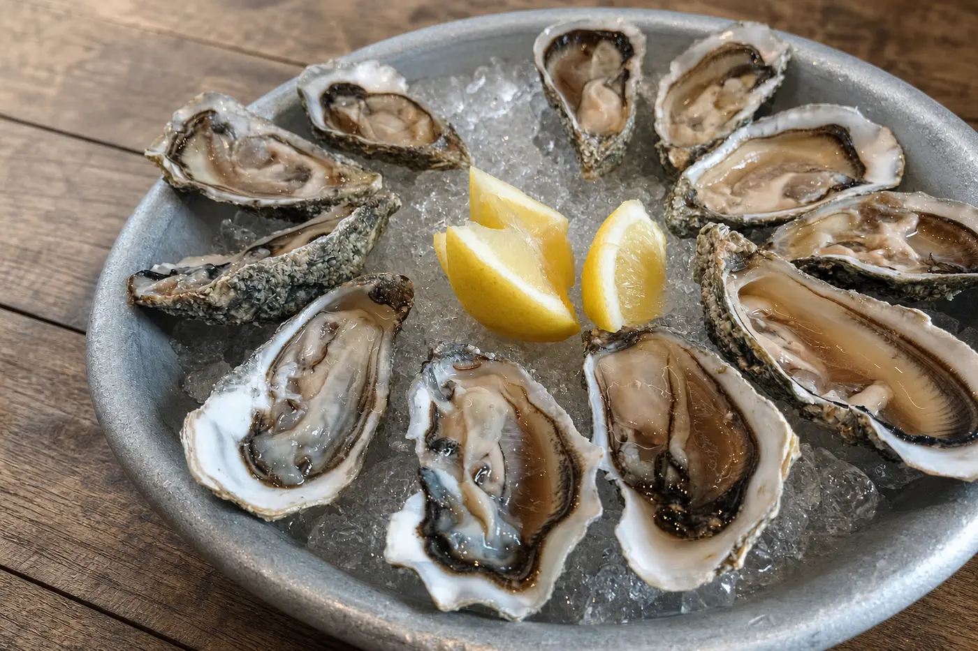 Plateau d'huîtres fraîches avec citron et glaçons sur assiette